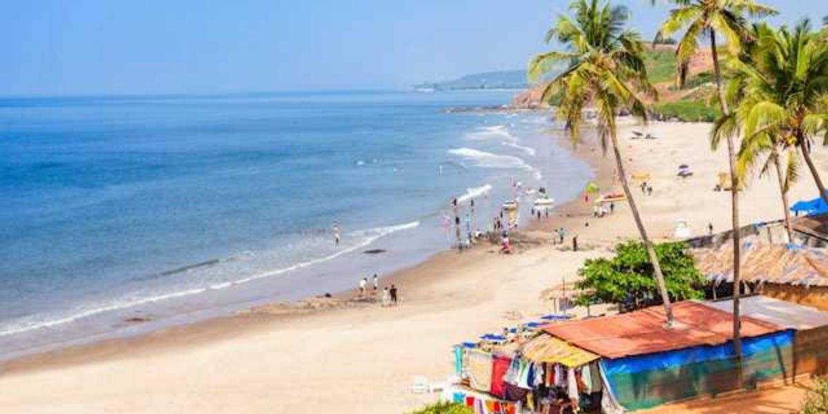 Colorful huts along a tropical beach with people on the sand