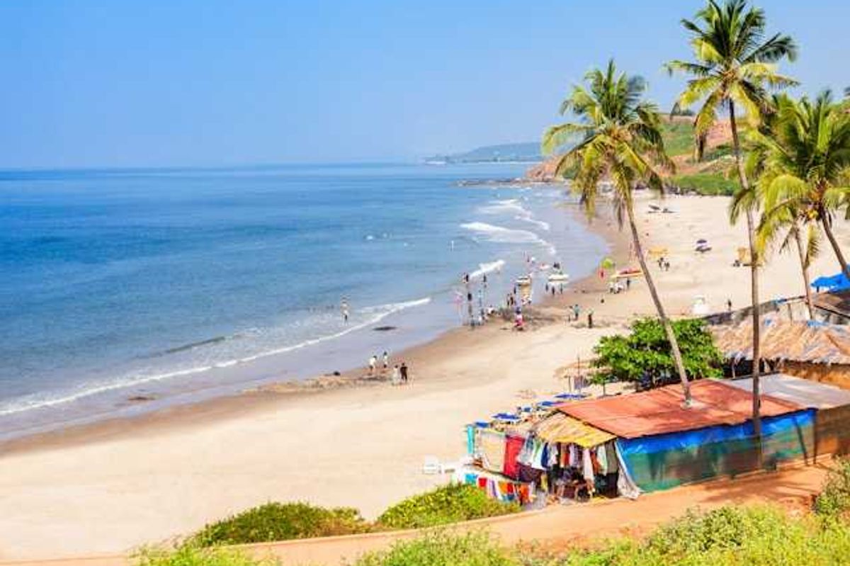 Colorful huts along a tropical beach with people on the sand