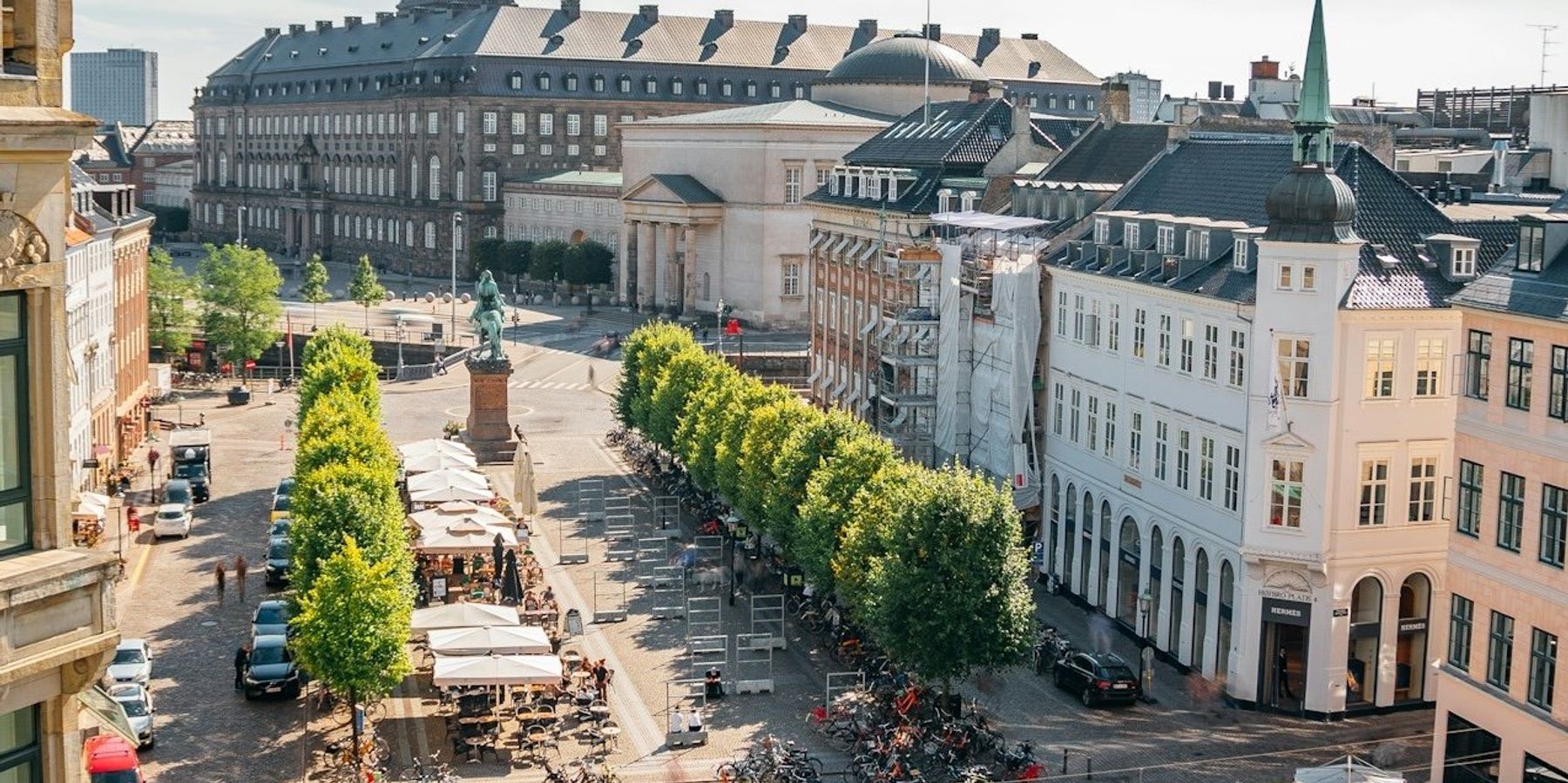 Copenhagen, Denmark central square viewed from above with bicycles, outdoor cafes and trees visible.