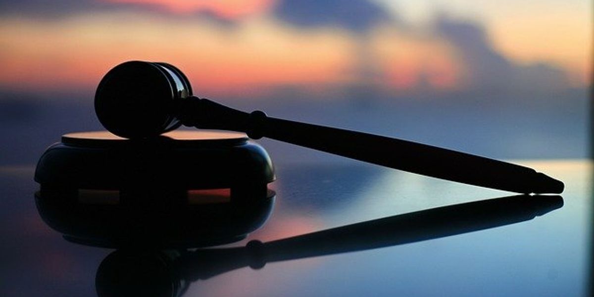 Courtroom gavel in front of blurred out background with pollution plumes.