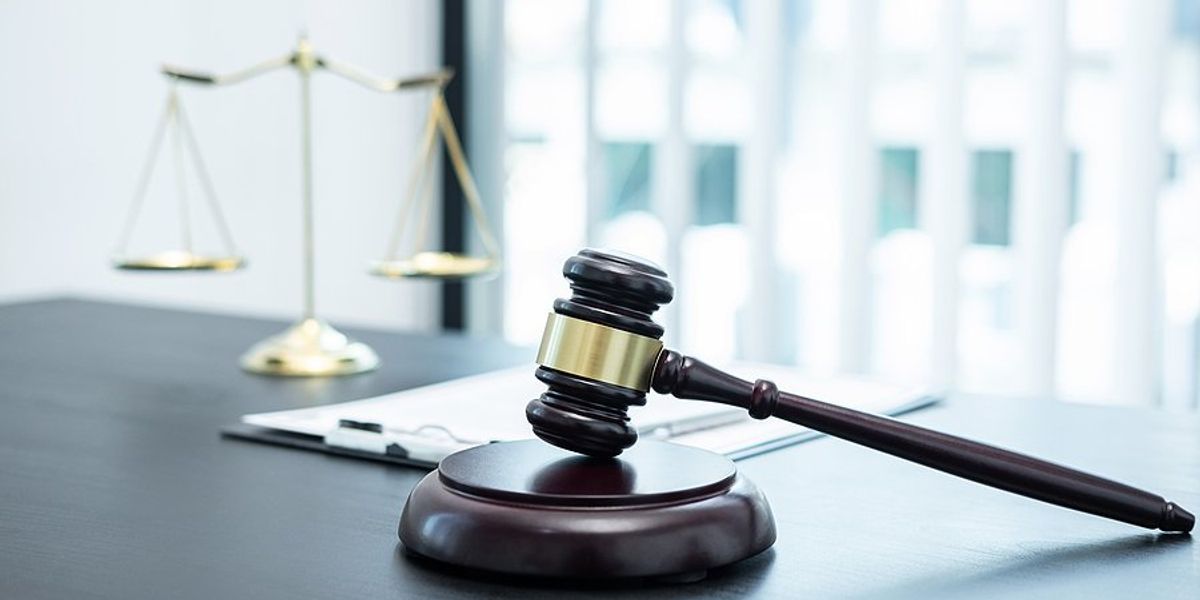 Courtroom gavel with the scales of justice in the background