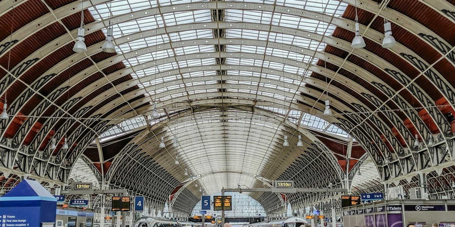 crowded airport terminal with arched glass ceiling.