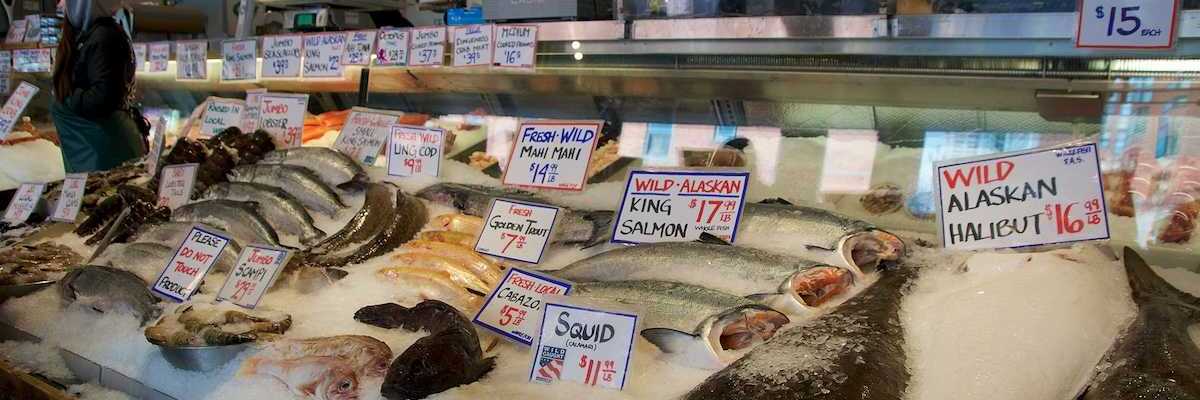 Customers at Pike Place Fish Company wait to order fish at the famous open air seafood market.