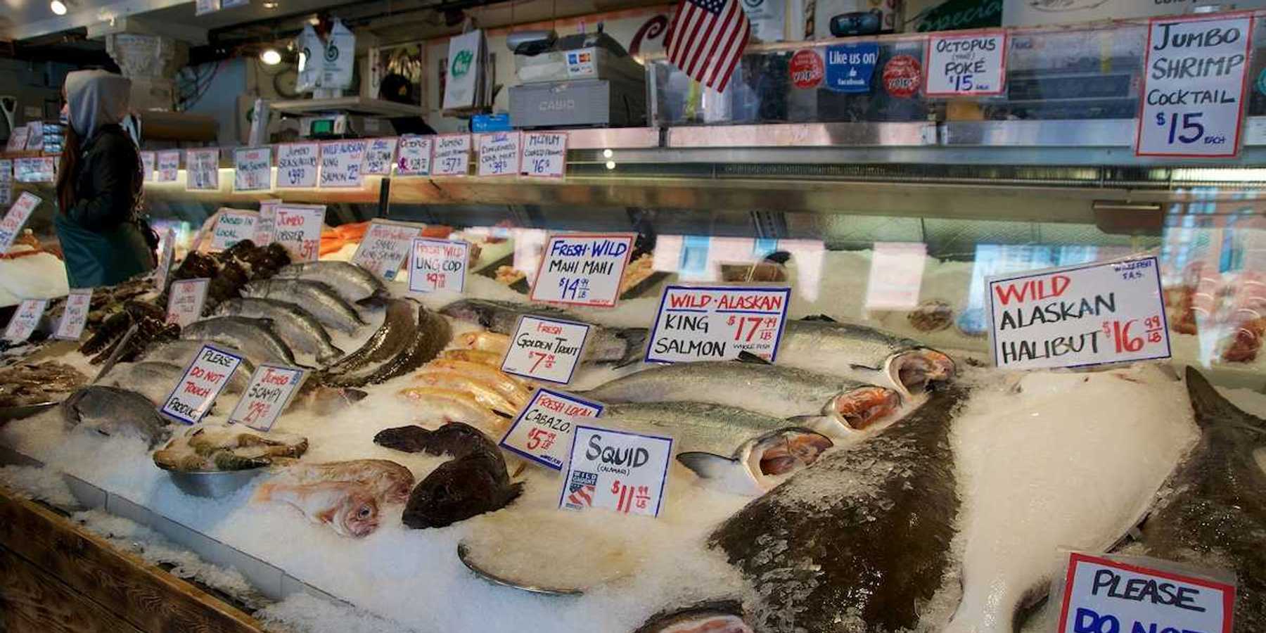 Customers at Pike Place Fish Company wait to order fish at the famous open air seafood market.