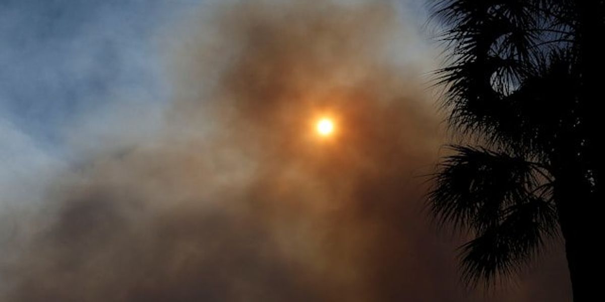 Dark wildfire smoke drifting in front of the sun.