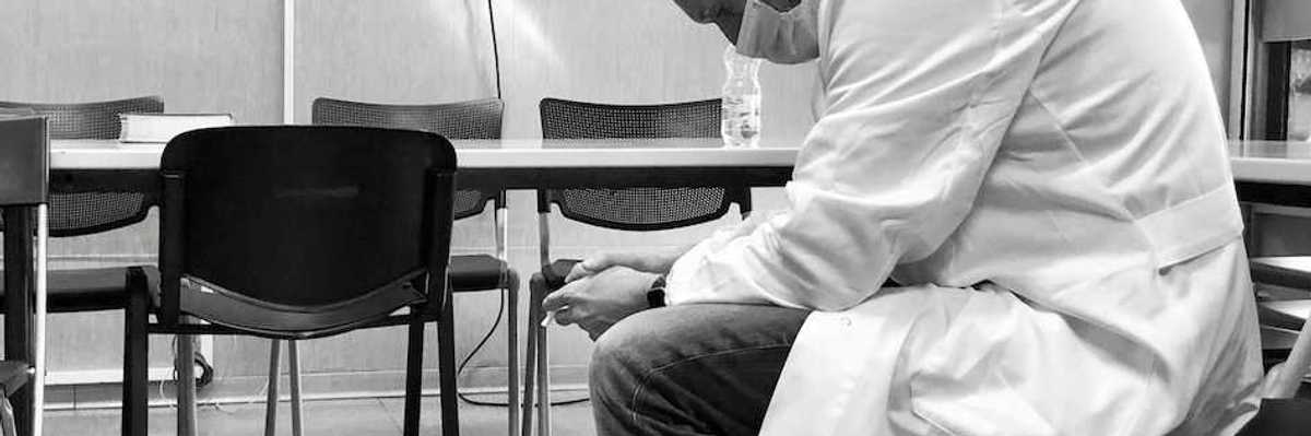 Dejected scientist in lab coat sitting in a chair