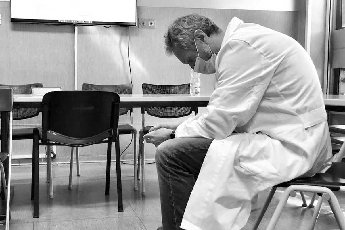 Dejected scientist in lab coat sitting in a chair