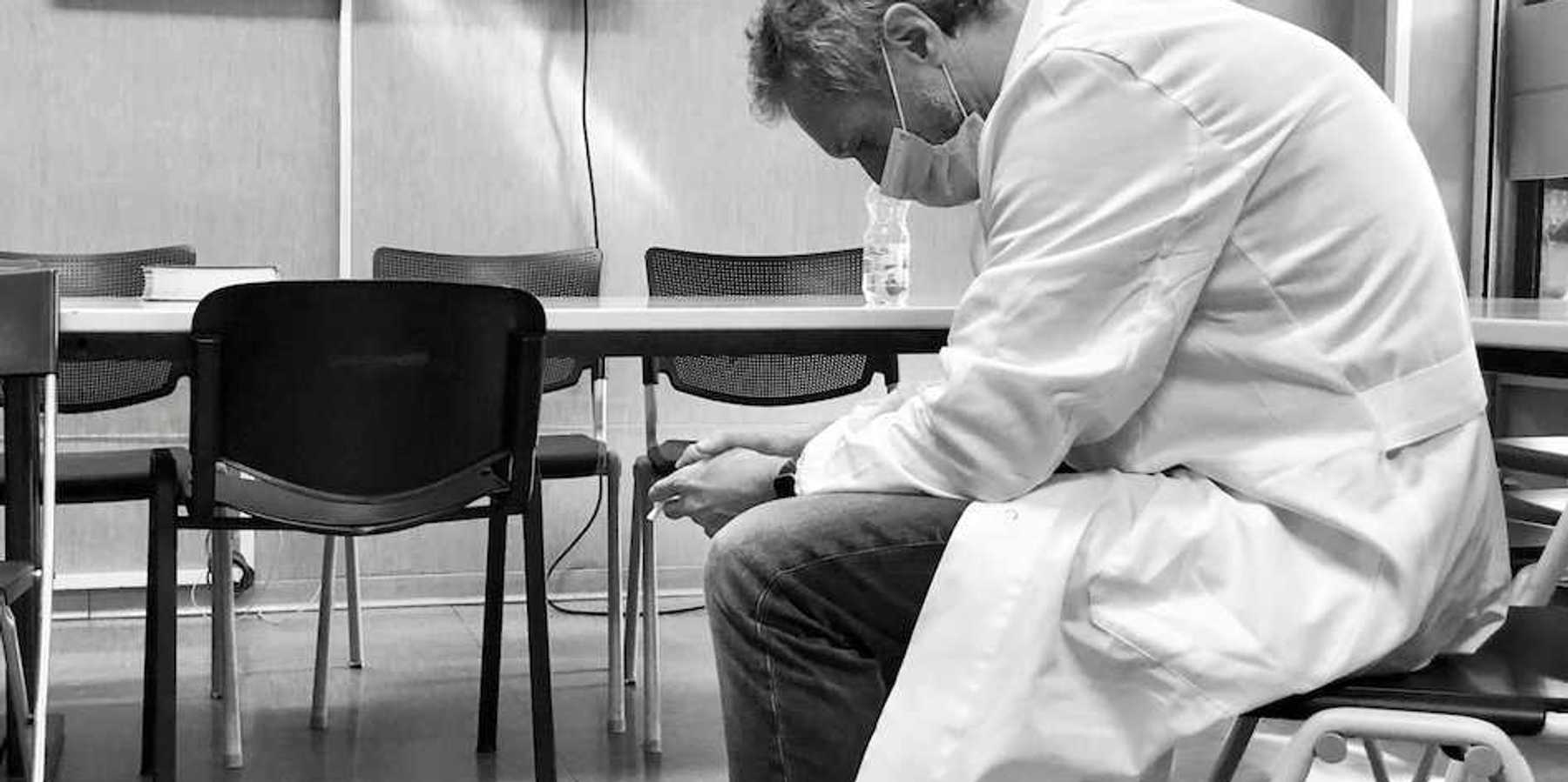Dejected scientist in lab coat sitting in a chair