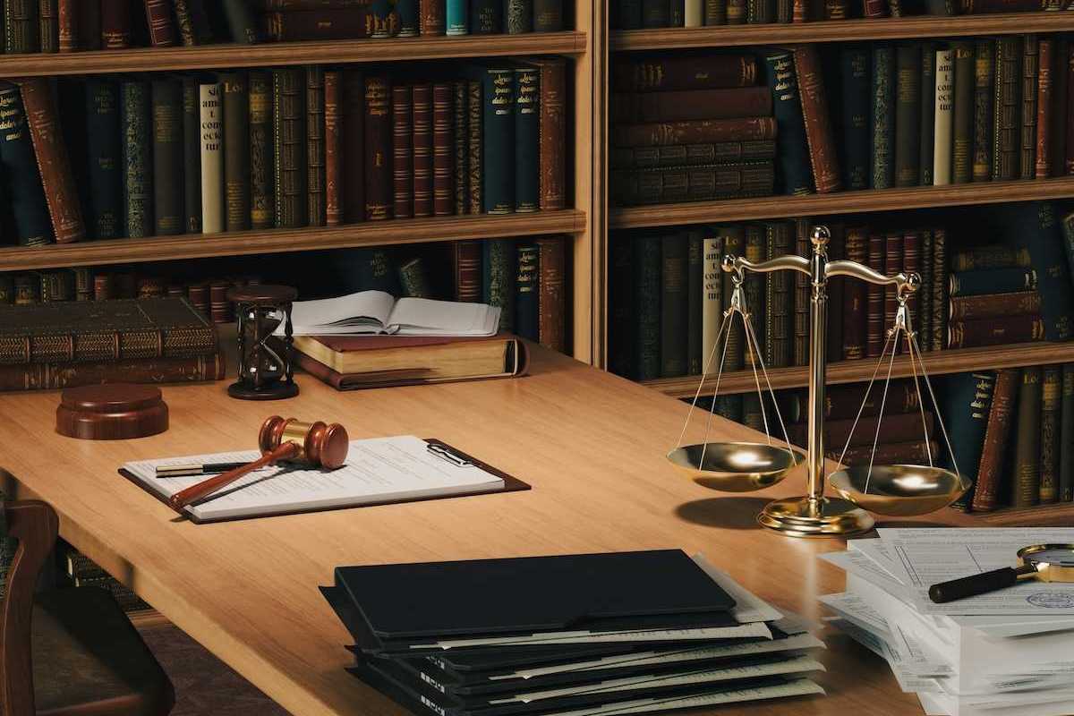 Desktop containing legal paperwork, gavel and scales representing justice