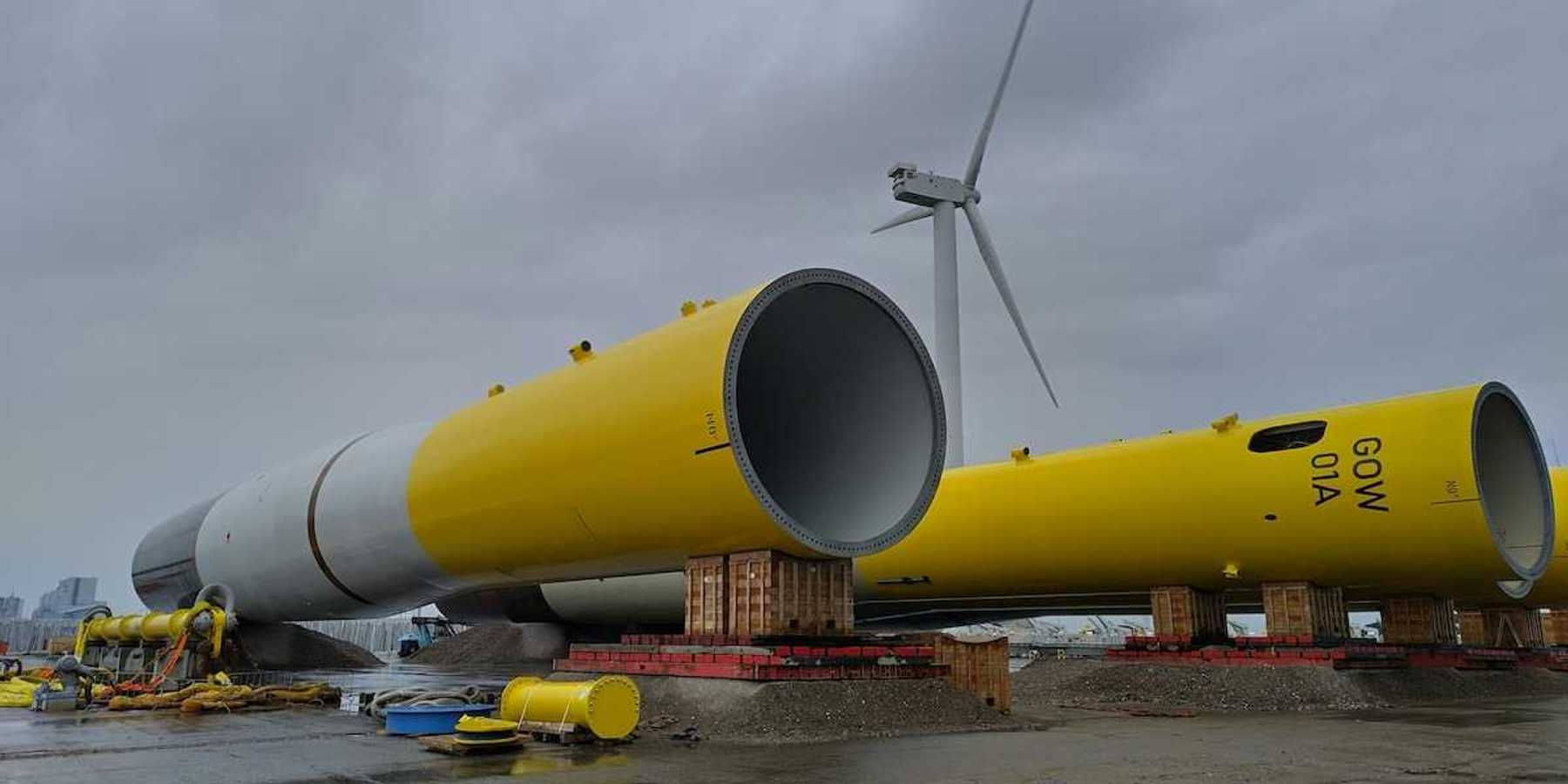 Dismantled, or yet to be assembled, yellow and white wind turbine tower, staged horizontally