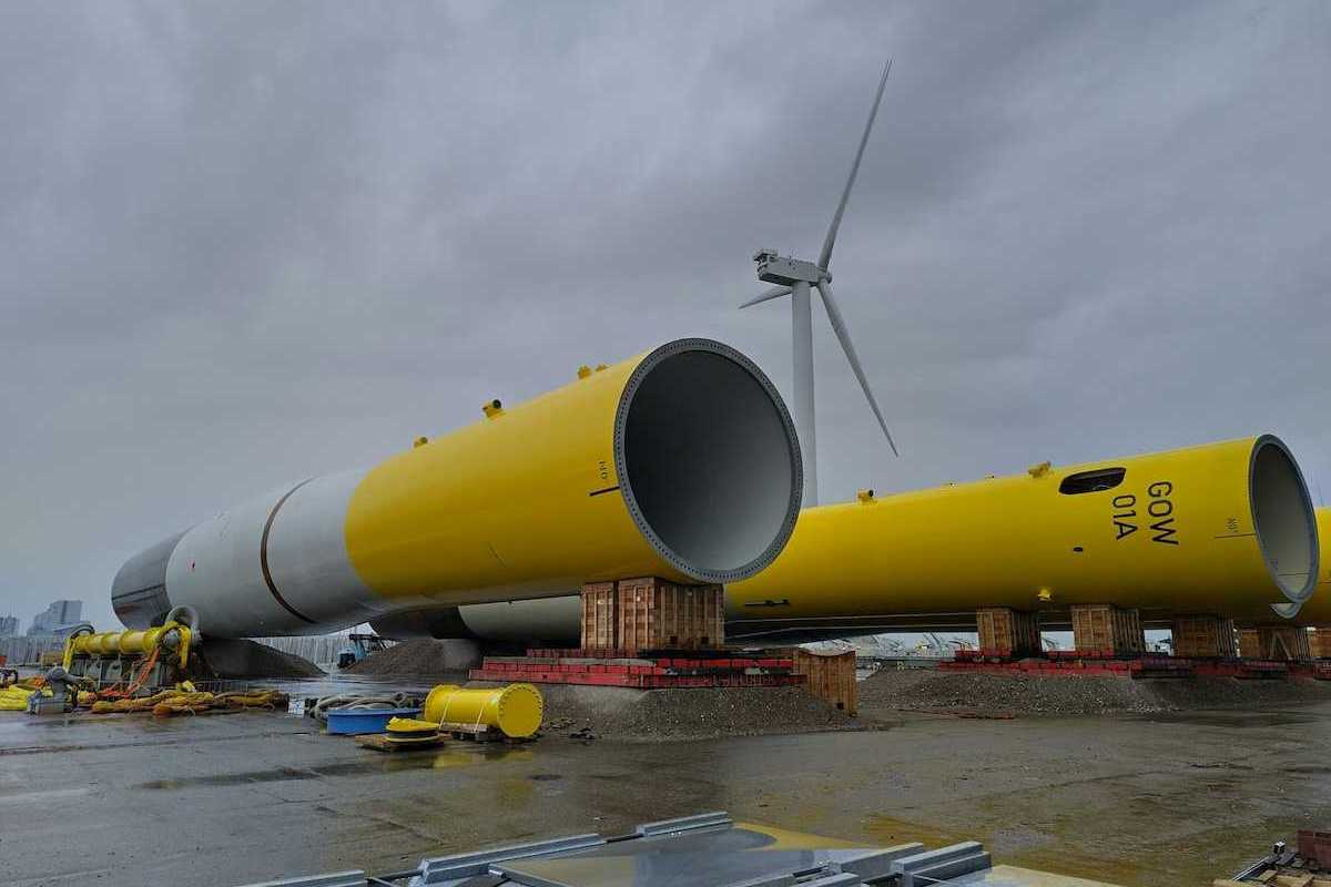 Dismantled yellow and white wind tower lying on the ground awaiting assembly