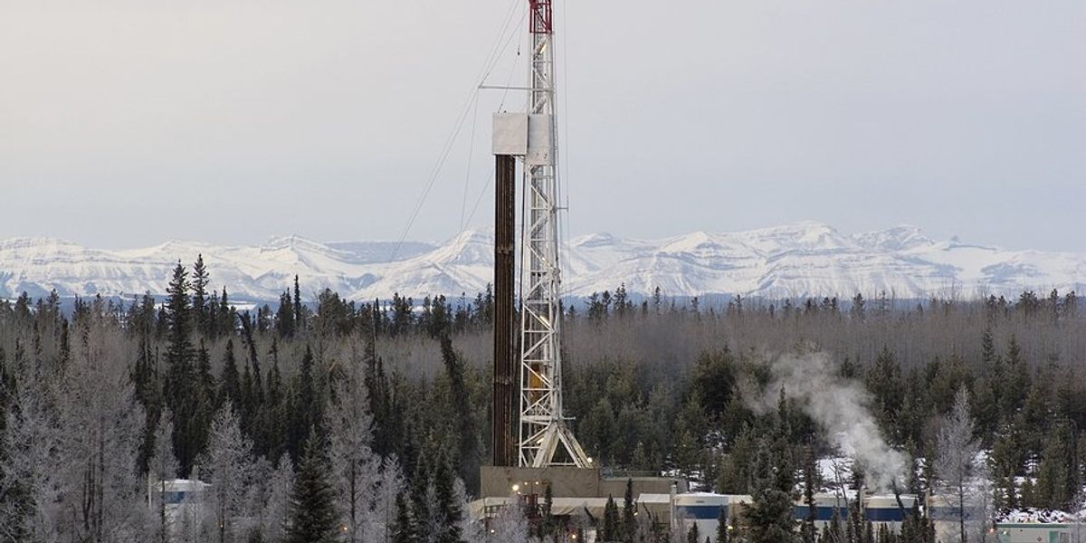 Drilling platform with snowy mountains in the distance.