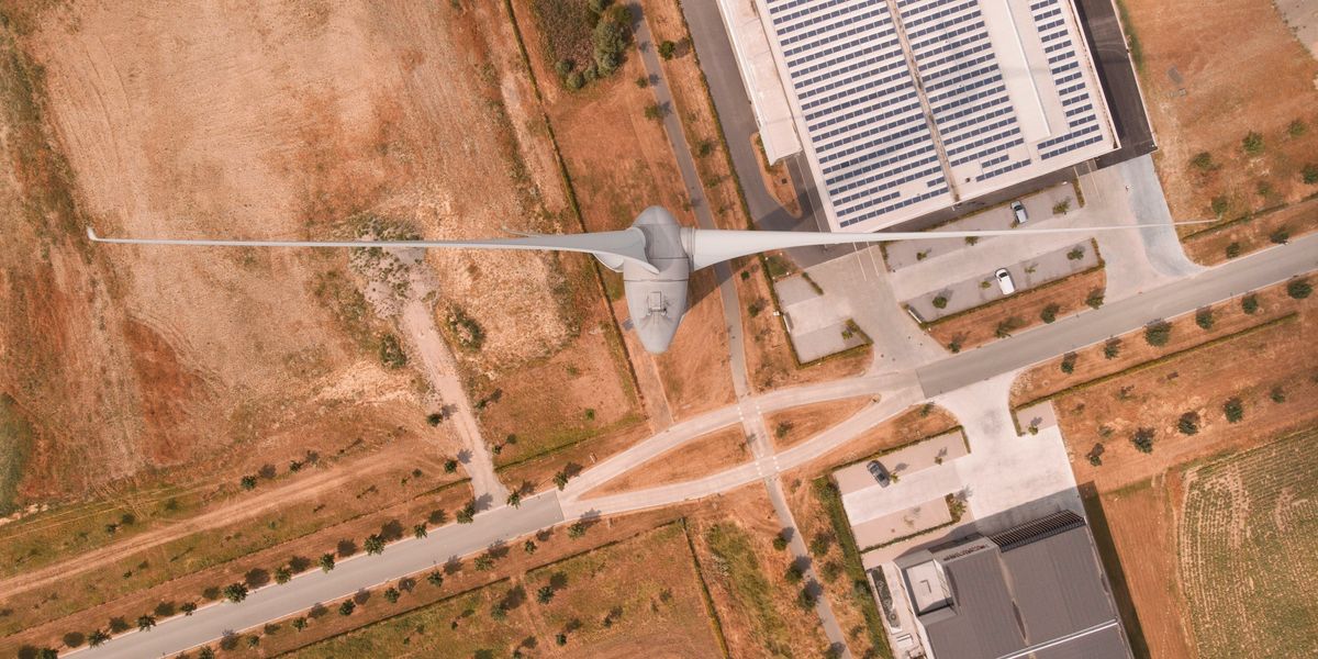 Drone view of a wind turbine and warehouses.