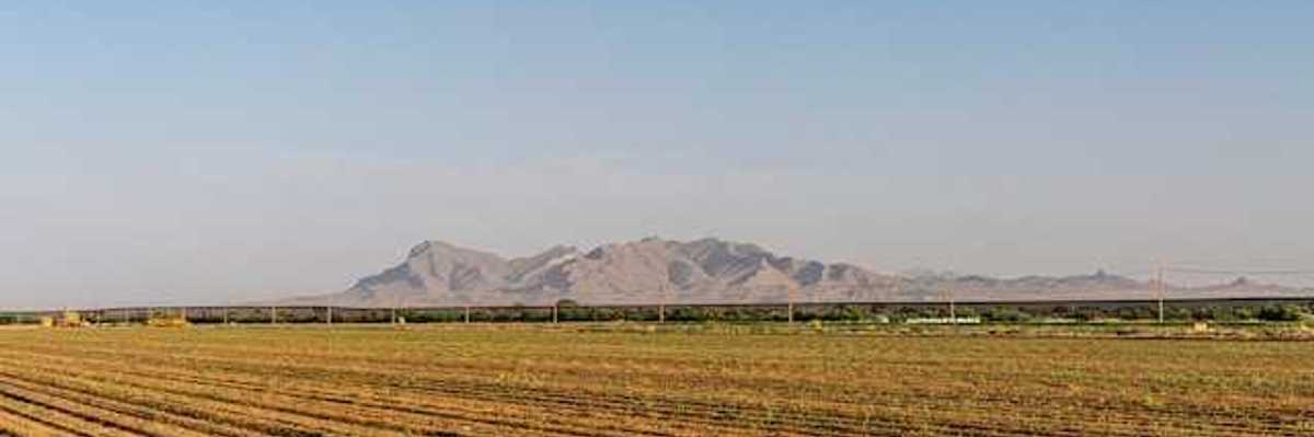 Dry farm fields with mountains in the background