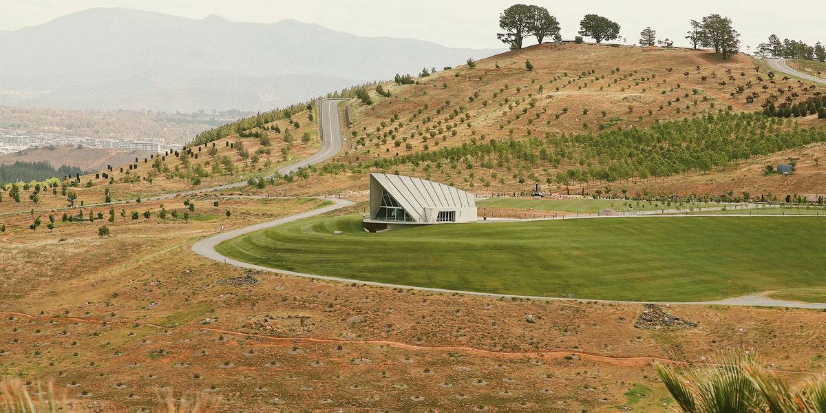 Dry landscape with hill, white house and trees in the background