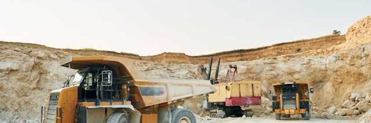 Dump trucks and mining equipment at the bottom of a mining pit