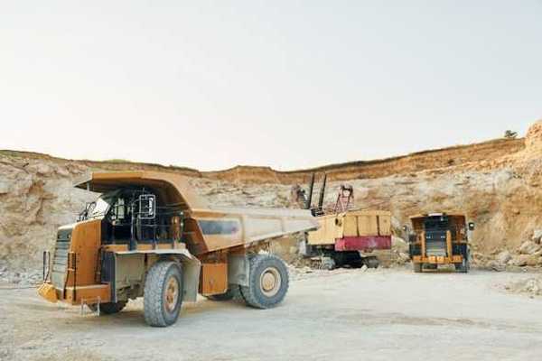 Dump trucks and mining equipment at the bottom of a mining pit