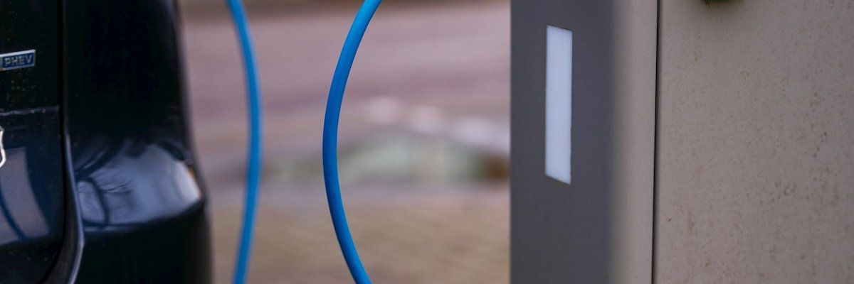 Electric vehicle plugged into charging station