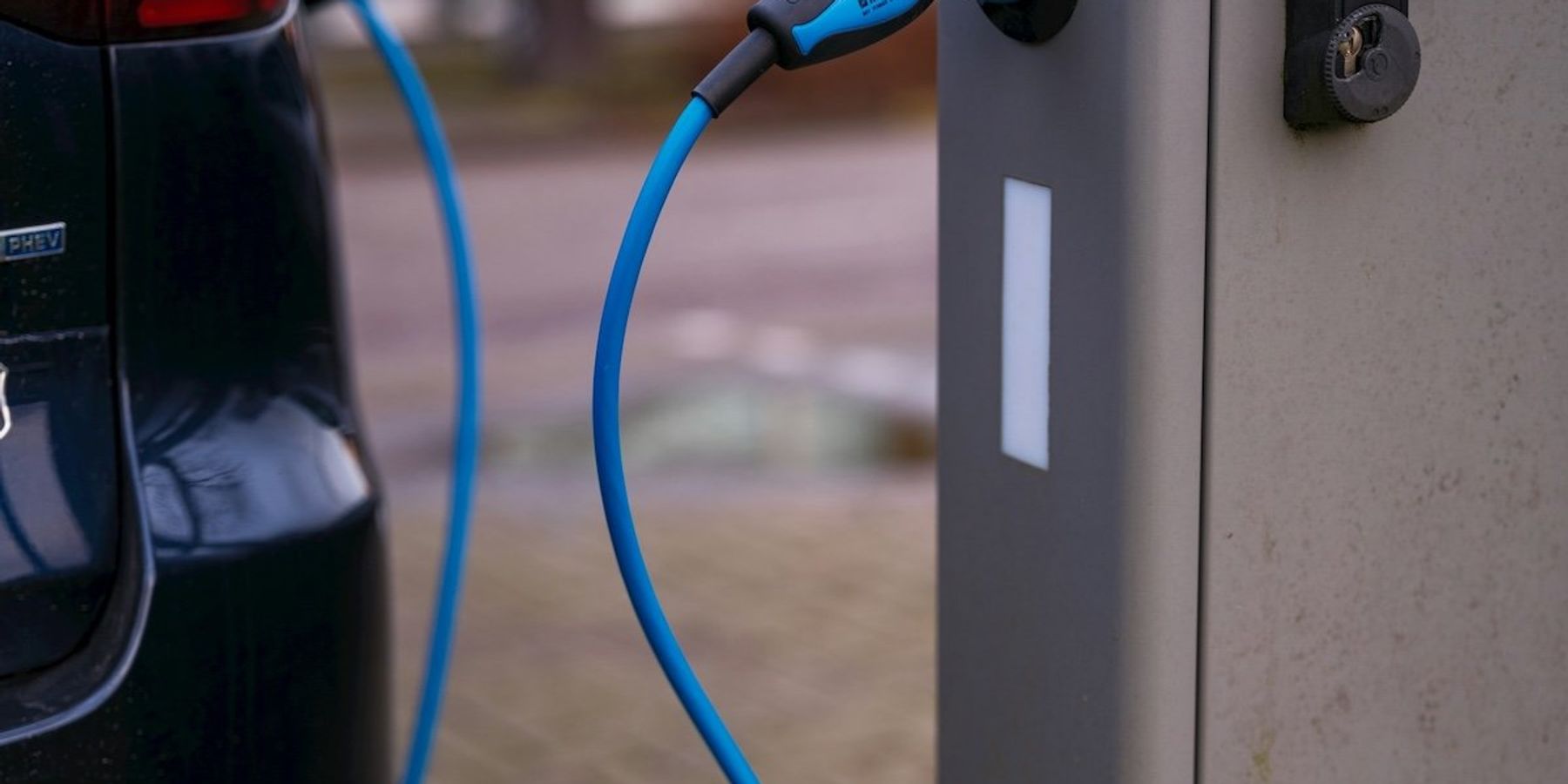 Electric vehicle plugged into charging station