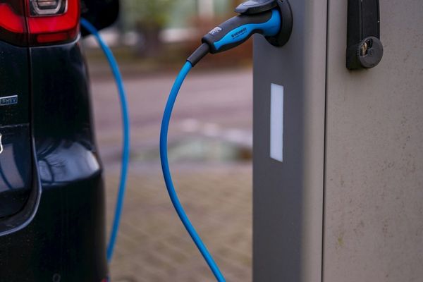 Electric vehicle plugged into charging station