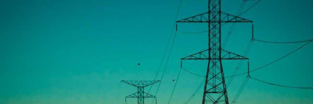 Electrical transmission lines against a rainbow-colored sky