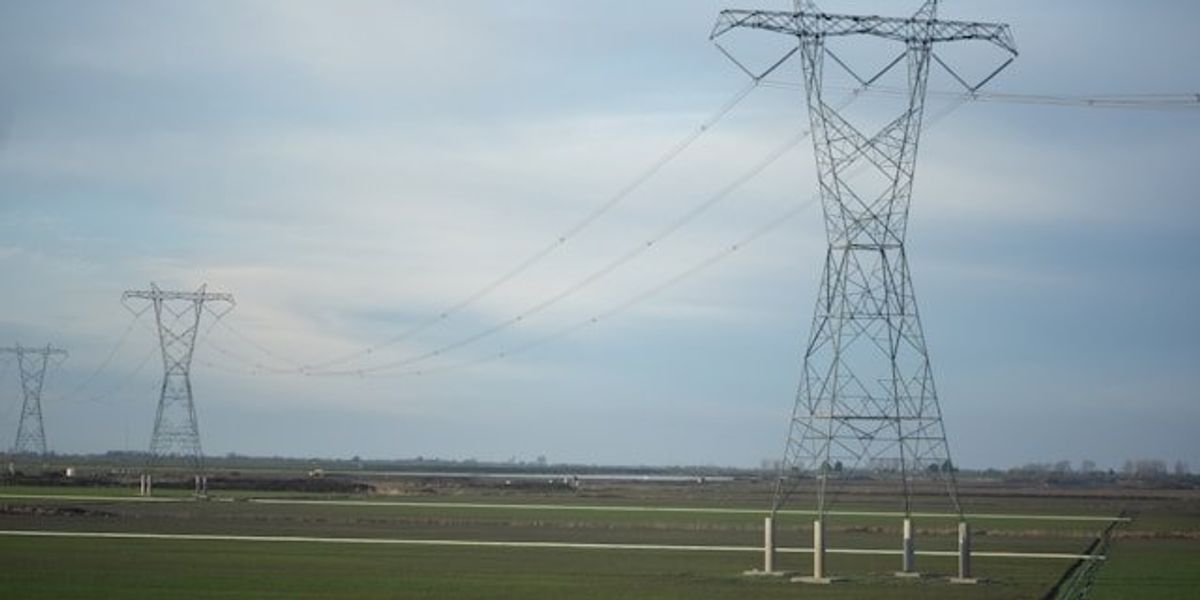 Electricity grid towers stretching across fields into the distance.