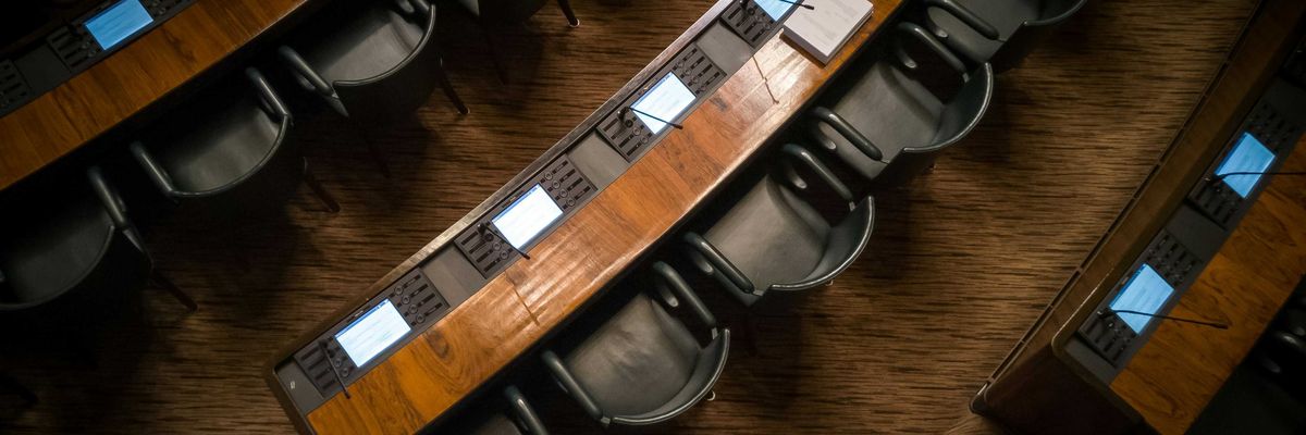 Empty chairs in rows inside a capitol building.