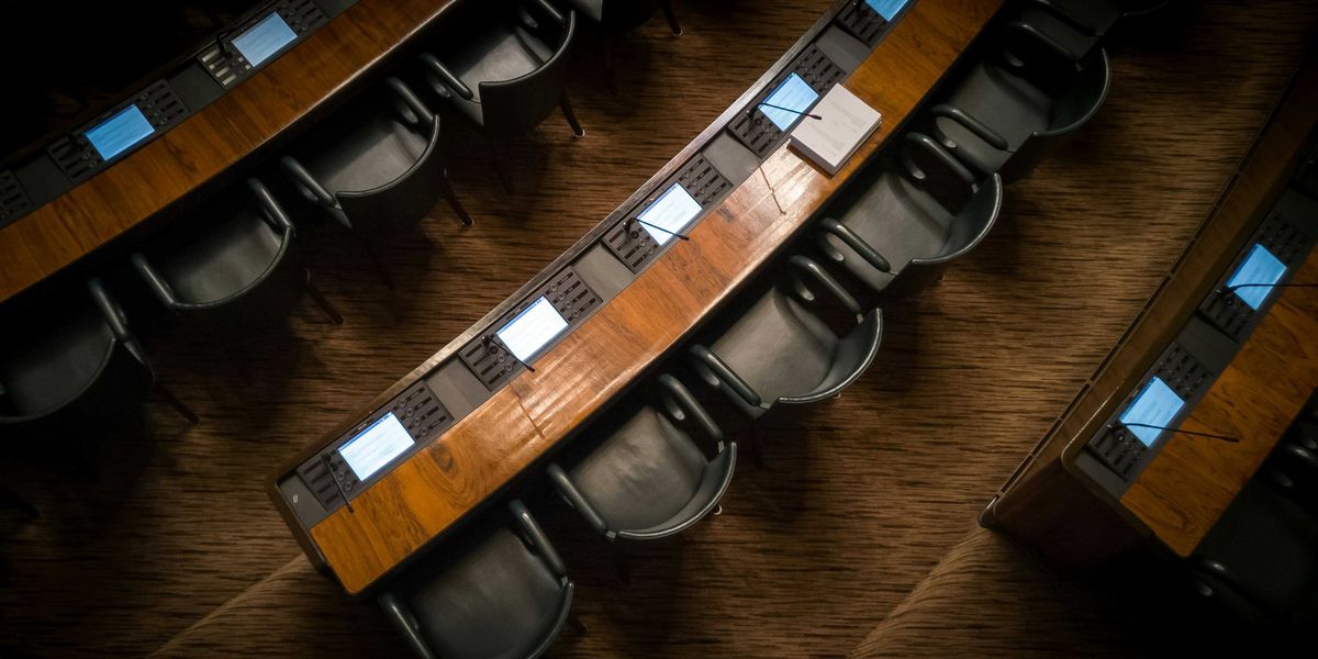 Empty chairs in rows inside a capitol building.