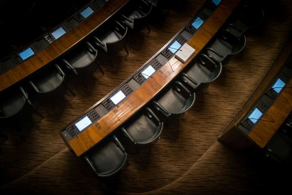 Empty chairs in rows inside a capitol building.