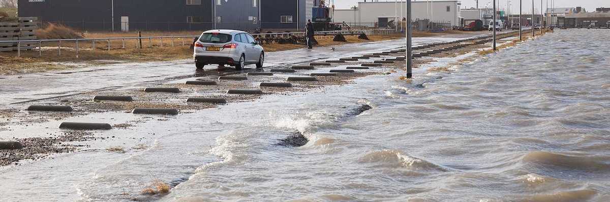 Extreme high tide and flooded roadway at the dikes of the Dutch coastal works