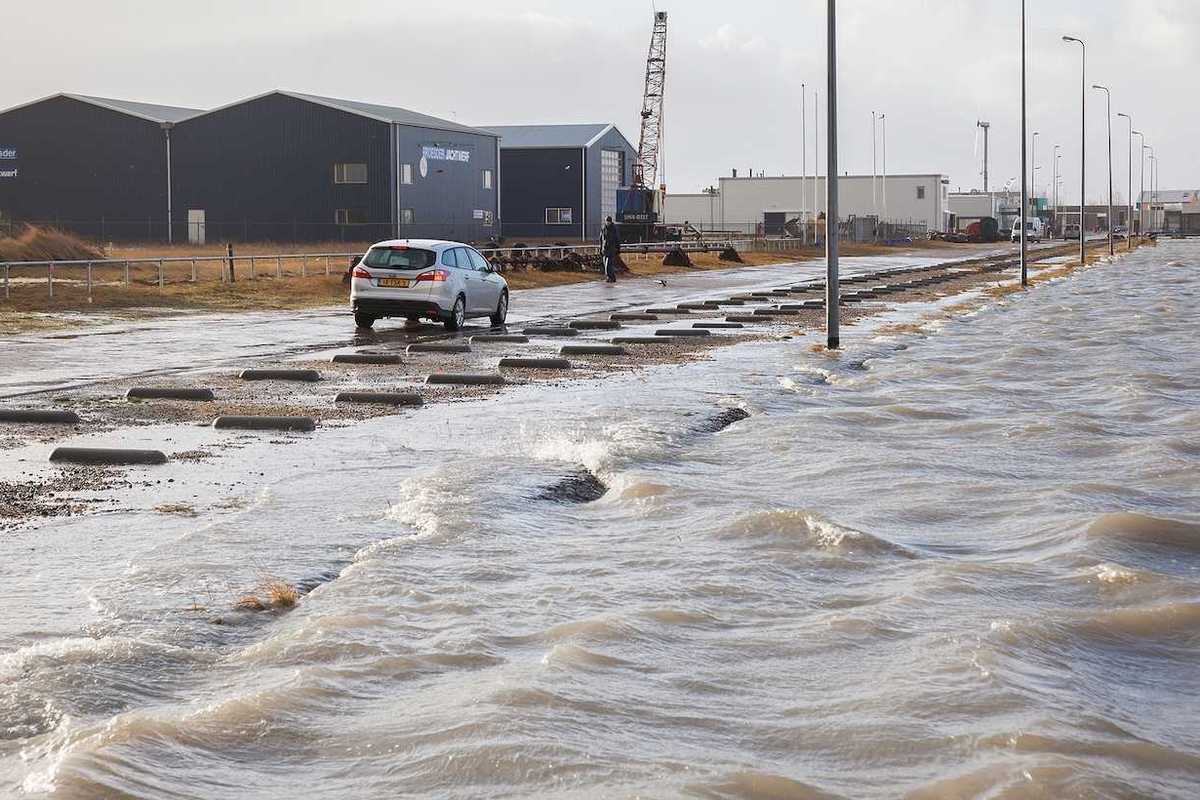 Extreme high tide and flooded roadway at the dikes of the Dutch coastal works