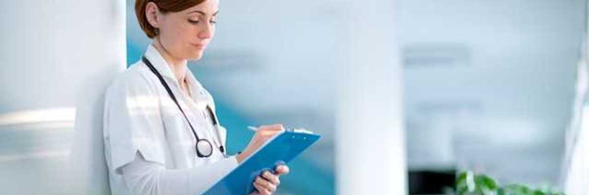 Female doctor writing on a clipboard in a hospital