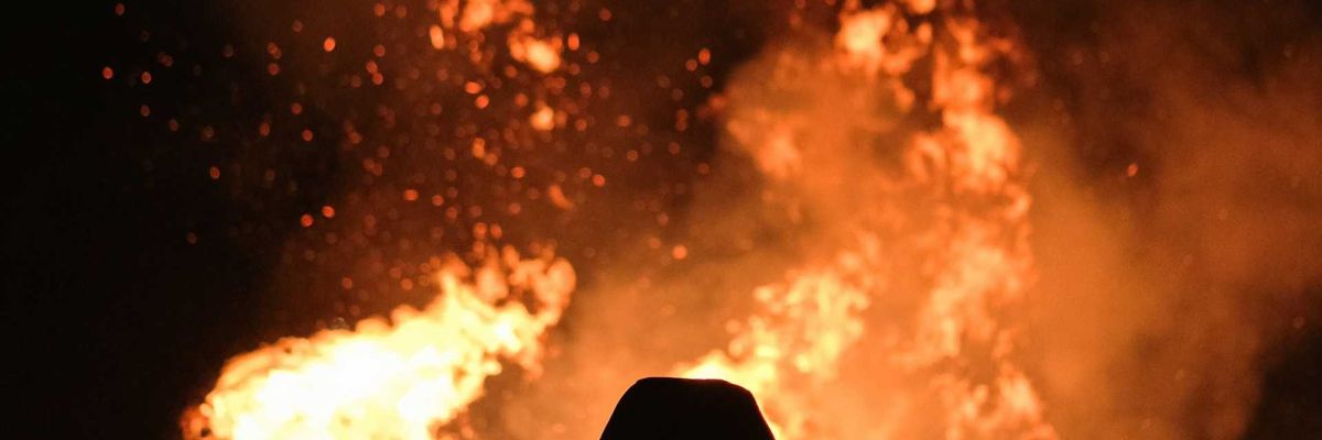 Figure silhouetted against wildfire