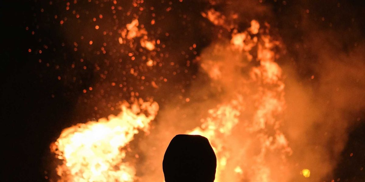 Figure silhouetted against wildfire