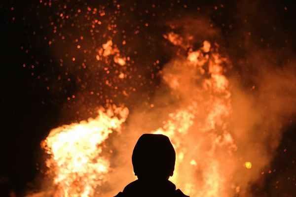 Figure silhouetted against wildfire