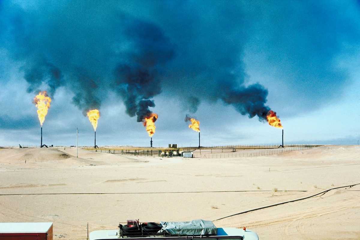 Five oil and gas wells burning off methane in a desert (Middle East) environment.