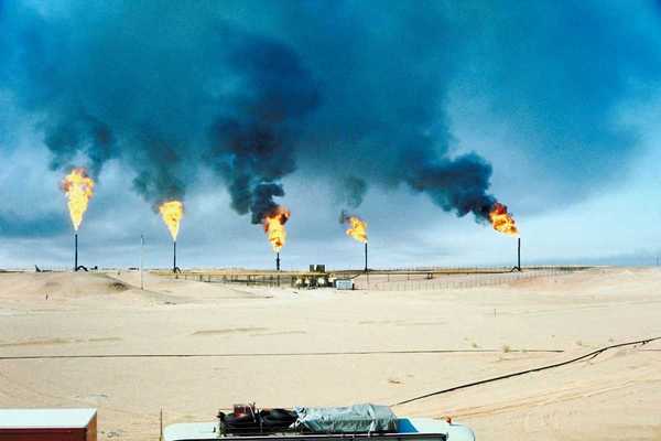 Five oil and gas wells burning off methane in a desert (Middle East) environment.