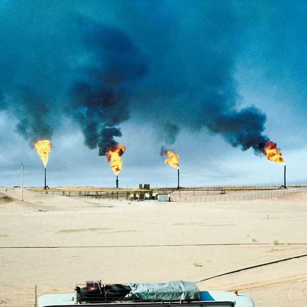 Five oil and gas wells burning off methane in a desert (Middle East) environment.