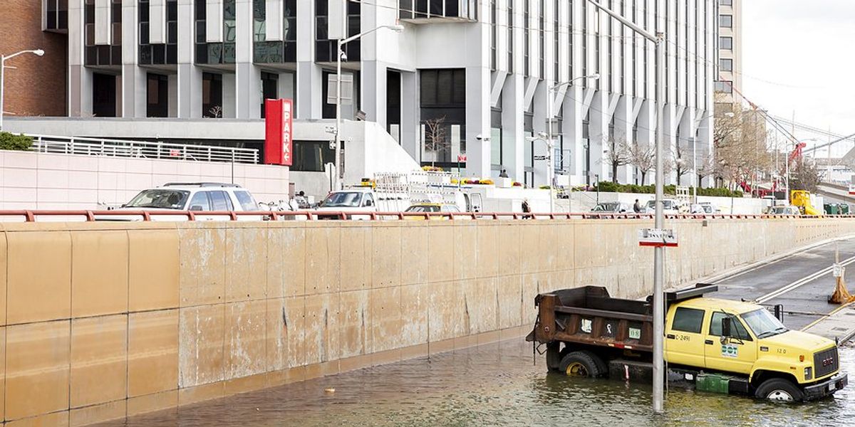 Flooded New York underpass with a yellow dump truck blocking traffic