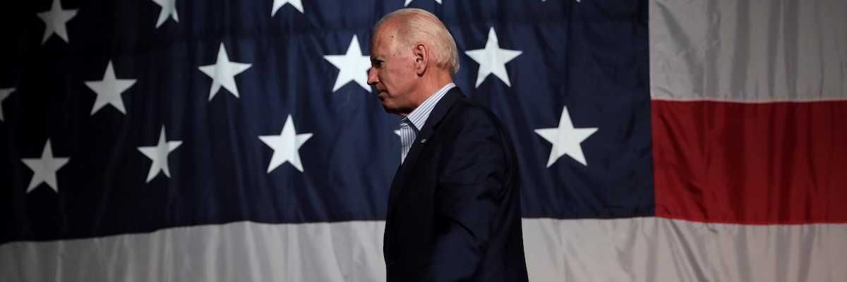 Former President of the United States Joe Biden with American flag backdrop