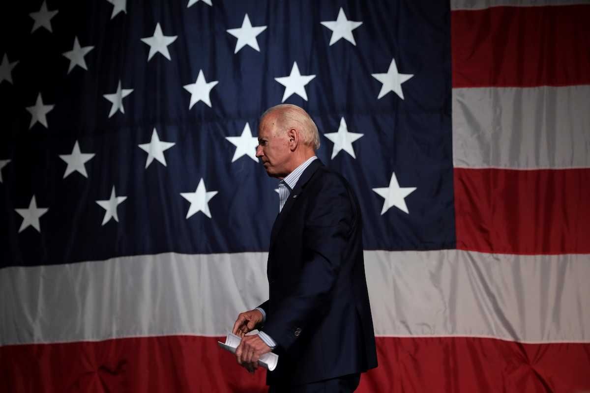 Former President of the United States Joe Biden with American flag backdrop
