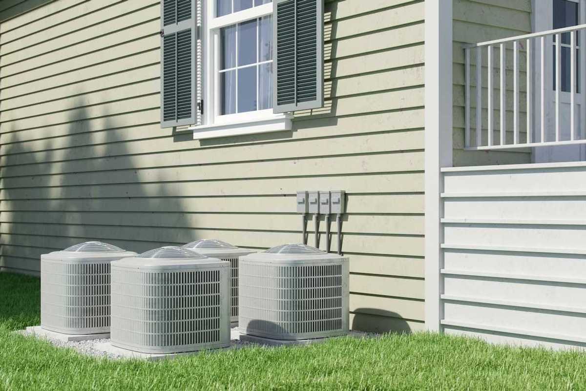 Four air conditioning units positioned next to a residential structure