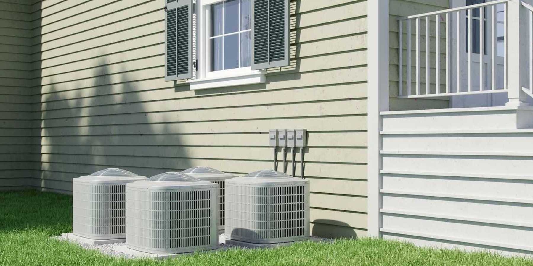 Four air conditioning units positioned next to a residential structure