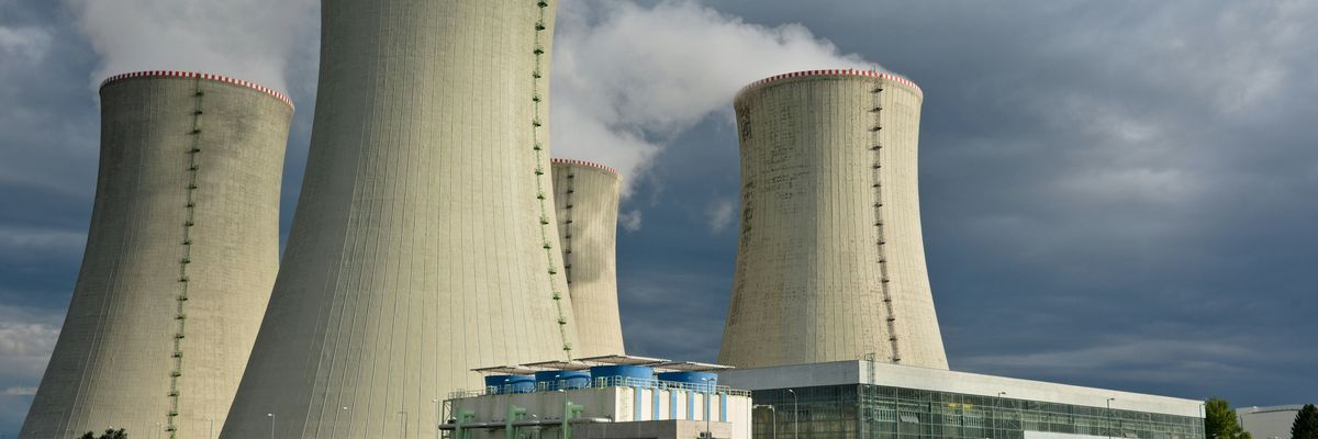 Four nuclear cooling towers set against a cloudy sky