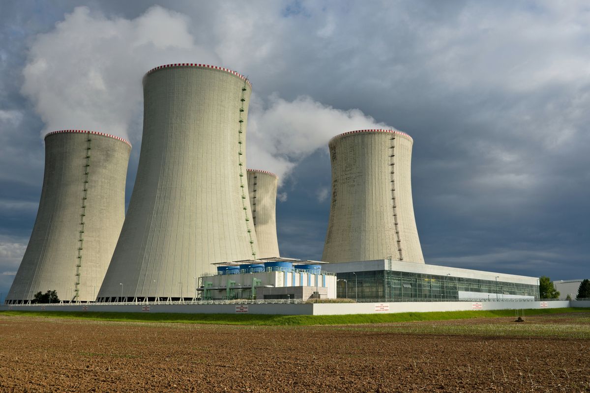 Four nuclear cooling towers set against a cloudy sky