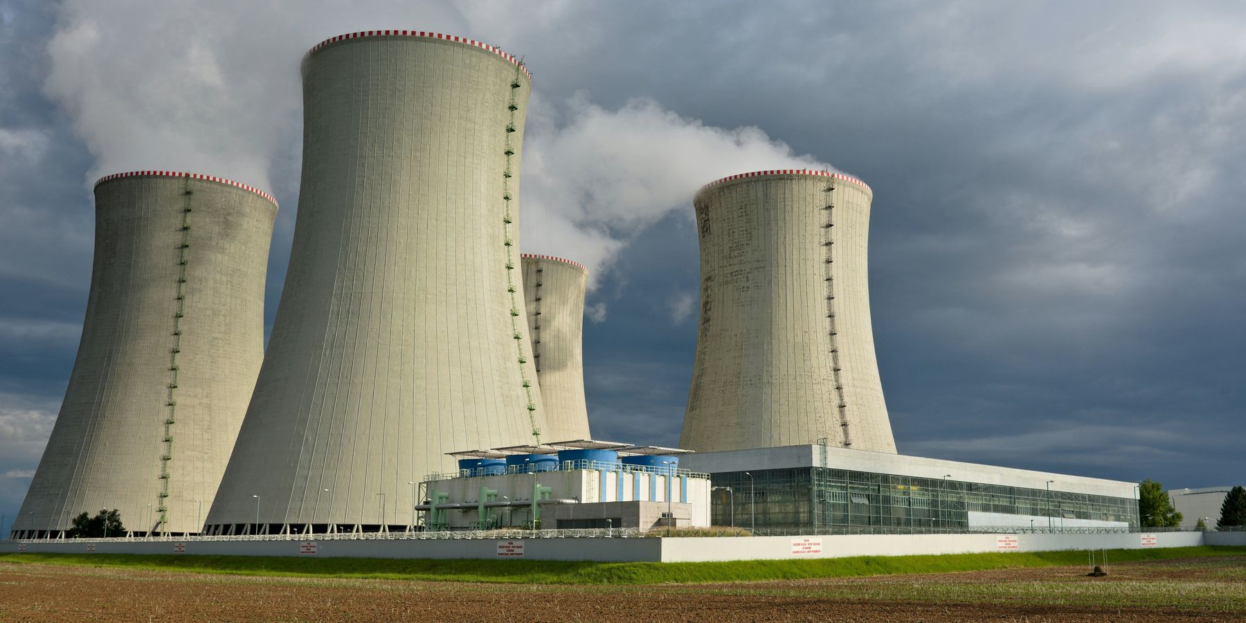 Four nuclear cooling towers set against a cloudy sky