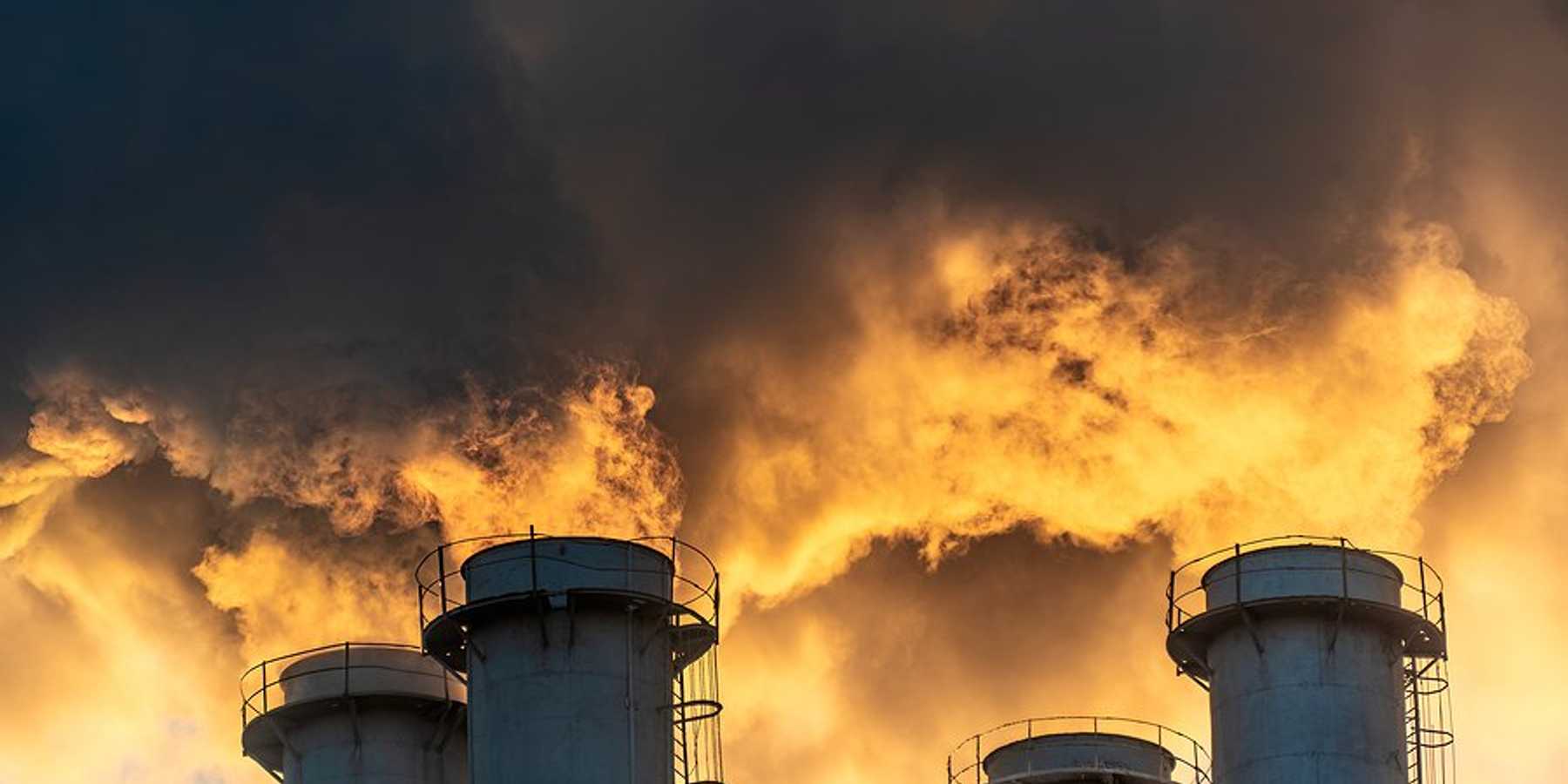 Four smokestacks billowing pollution