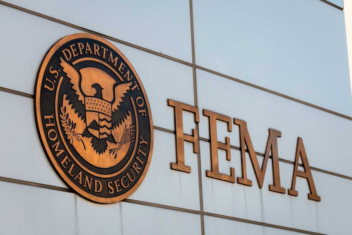 Gold-colored FEMA sign on building adjacent to Department of Homeland Security logo