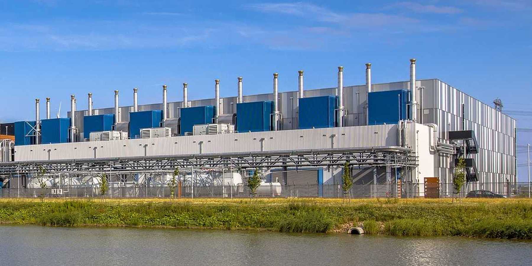 Google Datacenter adjacent to a waterway near Delfzijl in the province of Groningen, Netherlands, under blue sky.