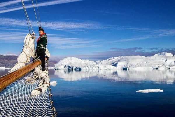 Greenland fisherman on his boat with ice floes in background